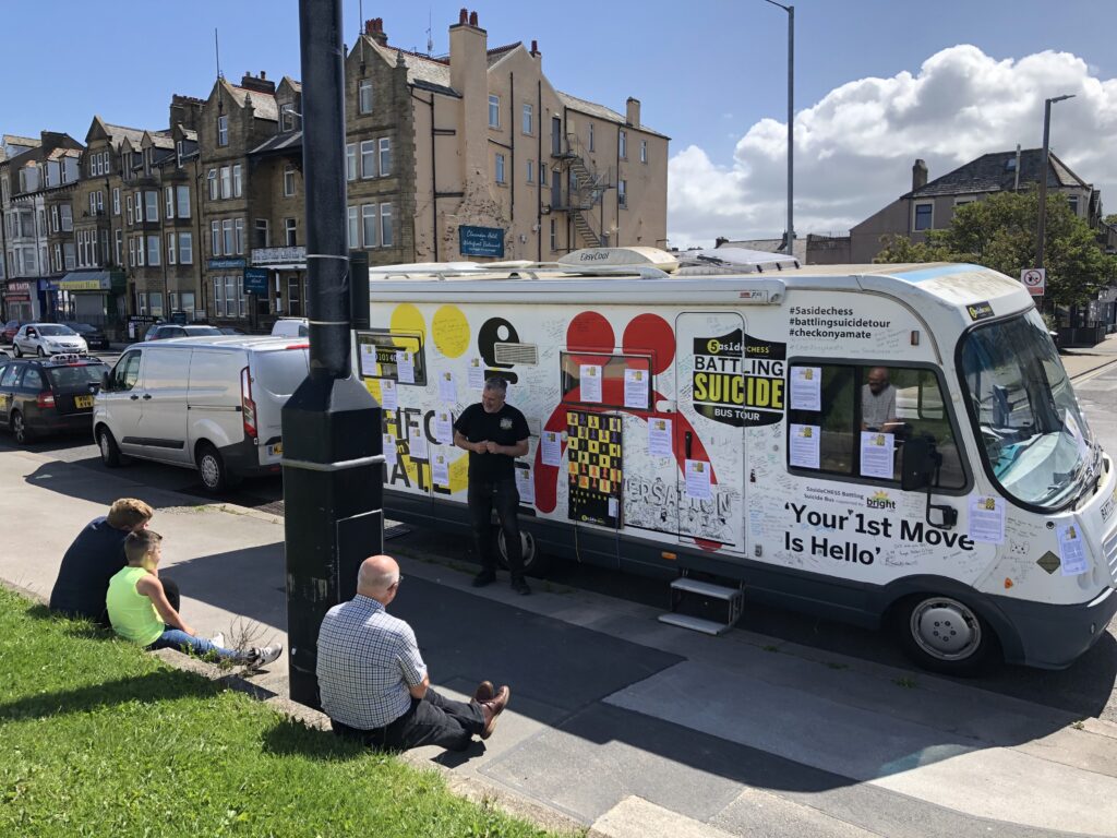 Battling suicide bus with finalist stories printed on the outside